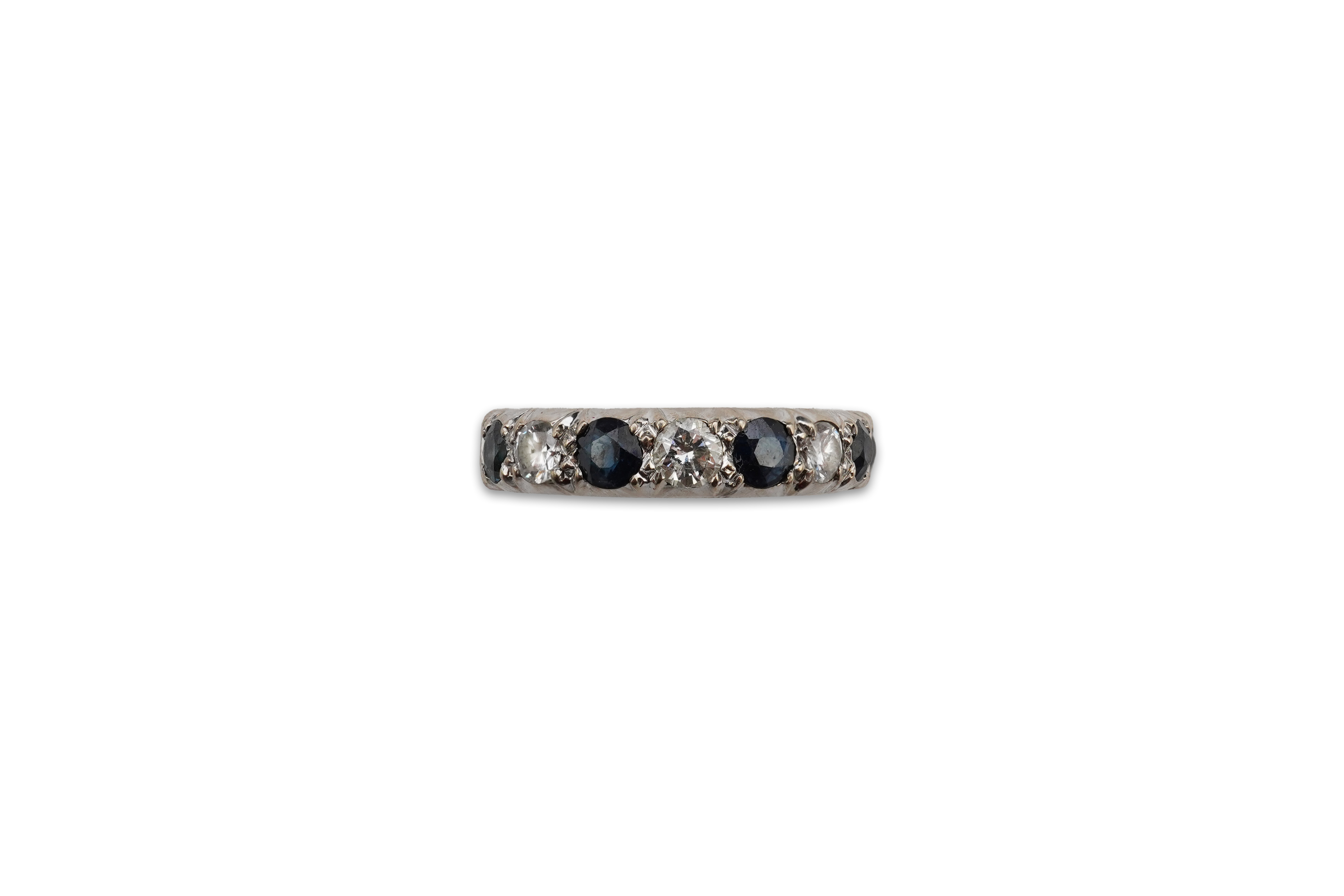 A sapphire and diamond half hoop ring, set with circular-cut diamonds totalling approximately 0.40 carats, and circular-cut sapphires, mounted in 18ct white gold, size N, British hallmarks, gross weight approximately 4.5
